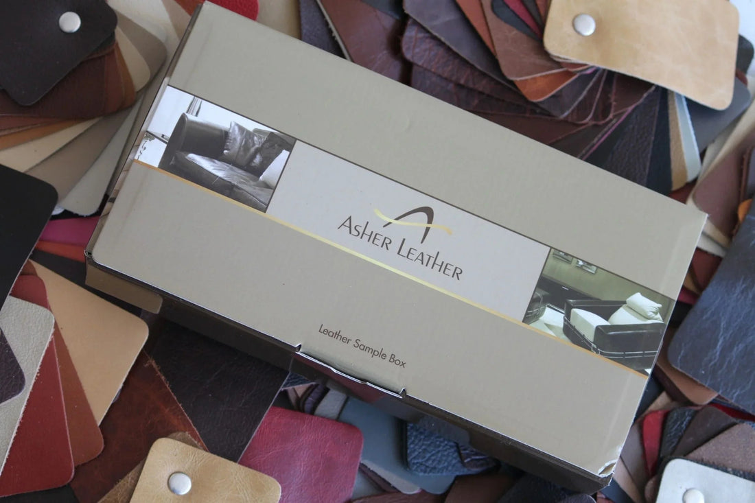 Asher Leather sample box on a surface covered with various leather swatches in multiple colors
